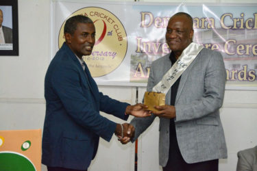 Minister of State Joseph Harmon (right) receiving a token of appreciation from President of the DCC, Alfred Mentore.  (Ministry of the Presidency photo) 