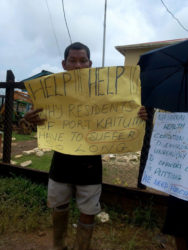 A Port Kaituma resident holding up his placard during Tuesday’s protest.