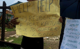 A Port Kaituma resident holding up his placard during Tuesday’s protest.