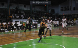 Jamaica’s Jason Menzies attempting a layup while being pursued by two Trinidad and Tobago players in their CBC u16 Championship group fixture at the Cliff Anderson Sports Hall
