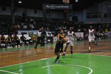 Jamaica’s Jason Menzies attempting a layup while being pursued by two Trinidad and Tobago players in their CBC u16 Championship group fixture at the Cliff Anderson Sports Hall 