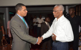 President David Granger (right) and Prime Minister Andrew Holness greeting each other at the Pegasus Hotel yesterday afternoon just before they sat down for bilateral talks. (Ministry of the Presidency photo)