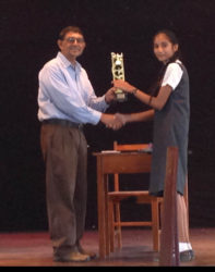 Chairman of the National Library Committee Petamber Persaud presenting an award to Sarah Dhanraj of the Bishops’ High School