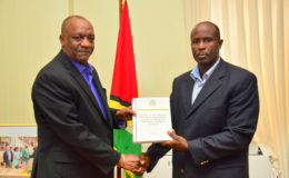  Minister of State Joseph Harmon receiving the report from Brigadier (Rtd) Bruce Lovell at the Ministry of the Presidency (Ministry of the Presidency photo)

