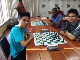 Haifeng Su (left) and Joshua Pedro ponder at the Andrew Arts Memorial Chess Tournament held at the National Resource Centre over the past two weekends. Su is attending Hunter College in Toronto, while Pedro is an Economics graduate of the University of Guyana. Su has been selected as a member of the 2016 Guyana Olympiad Chess Team which will represent the nation in Baku, Azerbaijan, in September. In the immediate background is Anthony Drayton, another member of the 2016 Guyana Olympiad chess team.