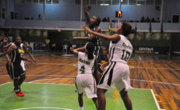 Shauliqua Fahie (centre) of BVI in the process of scoring a jump shot while being challenged by several Guyanese players during their matchup in the CBC Girls u16 Championship at the Cliff Anderson Sports Hall.