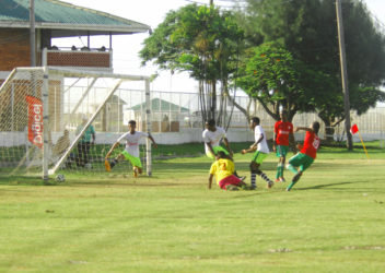 Job Caesar (No.10) of Chase Academy in the process of scoring his first goal against Bishops’ High during their matchup in the Georgetown North Zone final of the Digicel Schools Football Championship at the Camp Ayanganna ground 