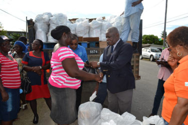 Minister of Citizenship, Winston Felix (right) presents a parcel to one recipient at the Community Development Centre at Union Village. (Ministry of the Presidency photo) 
