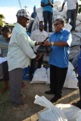Rajkumar Suhkra and CDC Chairman Colonel (ret’d) Chabilall Ramsarup (right) share a light joke as he collects his hamper at the Union/Naarstigheid Neighbourhood Democratic Council at Bush Lot. (Ministry of the Presidency photo)