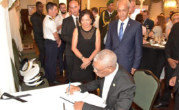 This Ministry of the Presidency photo shows President David Granger signing the book of condolence.