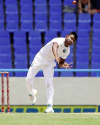 West Indies leg-spinner Devendra Bishoo sends down a delivery during his three-wicket haul against India on the opening day of the first Test. (Photo courtesy WICB) 