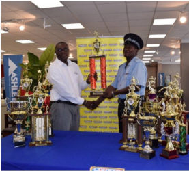 President of Courts’ Sports Club, Ricardo Manbodh, hands over the trophies to Coach of the Police Sports Club, Linden Wilson.