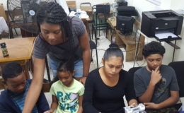 Asha Christian (standing) with children at the local Robotics gathering