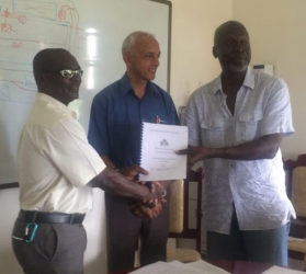 Permanent Secretary Emil McGarrell (at left) and environmental consultant Samuel Wright along with Minister Ronald Bulkan (centre) after the signing of the contract. 