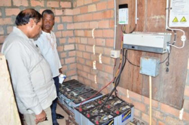 Prime Minister Moses Nagamootoo (left) and Radio Paiwomak Coordinator Virgil Harding inspecting the batteries donated by OPM. (OPM photo)
