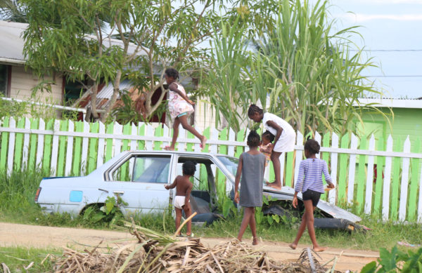 School’s out and an abandoned car in ‘C’ Field Sophia served as a play area for these children yesterday. (Photo by Keno George)