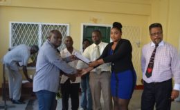 The report being handed over by labour officers Roydon Croal (centre) and Latoya John (second from right) to Town Clerk Royston King (left) accompanied by Chief Labour Officer Charles Ogle (right). GINA photo)