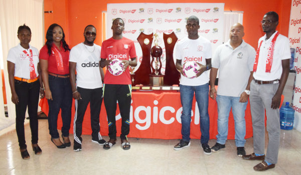 Captain of Wismar/Christianburg Keshawn Dey (4th from left) and skipper of Chase Academy Jeremy Garrett (3rd from right) posing alongside the championship trophy while Wismar/Christianburg coach Delon Peters (3rd from left) and Chase Academy owner Henry Chase (2nd from right) and Digicel Representatives look on. 