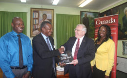 Speaker of the National Assembly, Dr. Barton Scotland (second from left) receives a book, on British Colombia, from Canadian High Commissioner, Pierre Giroux.  Also in the photo is Head Librarian, Michael Monroe (left) and Parliamentary Researcher, Carla Isaacs.