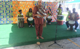 Bishop Andre Irving (centre) performing a libation and African prayer accompanied by drumming performed by the Buxton Fusion Group (background) during the Ministry of Education, Department of Culture, Youth and Sport’s launching of Emancipation celebrations yesterday.  (Dhanash Ramroop photo)