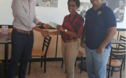 Clinton Urling, Proprietor of German’s Restaurant hands over the sponsorship cheque to Kanimas skipper Nia Gonsalves in the presence of Guyana Baseball League (GBL) President Robin Singh.