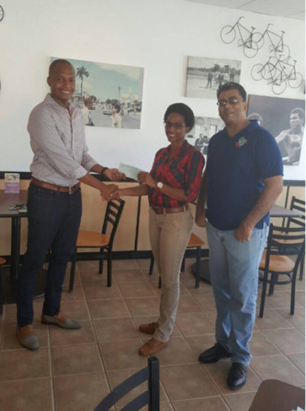Clinton Urling, Proprietor of German’s Restaurant hands over the sponsorship cheque to Kanimas skipper Nia Gonsalves in the presence of Guyana Baseball League (GBL) President Robin Singh.