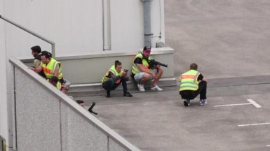 A screen grab taken from video footage shows plain clothes police officers taking cover in the car park of the Olympia shopping mall during shooting rampage in Munich, Germany July 22, 2016. dedinac/Marc Mueller/handout via REUTERS 