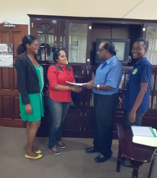 Chief Executive Officer of NAREI, Dr. Oudho Homenauth (second from right) presents a copy of the contract to the contractor S&K Construction Services. Also in the picture are head of the Mangroves Department Kene Moseley and NAREI's Engineer Luandra Jack. (Ministry of Agriculture photo)