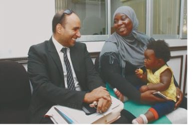 With her 14-month daughter Kaylee seated on her lap, Giselle Glaude shares a light moment with her attorney, Jason Nathu, at the Equal Opportunity Tribunal building before judgment was delivered in her favour yesterday.