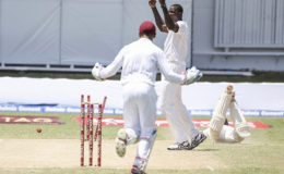 West Indies captain Jason Holder and wicketkeeper Shane Dowrich celebrate the run out of Chesteshwar Pujara. (Photo courtesy WICB Media) 
