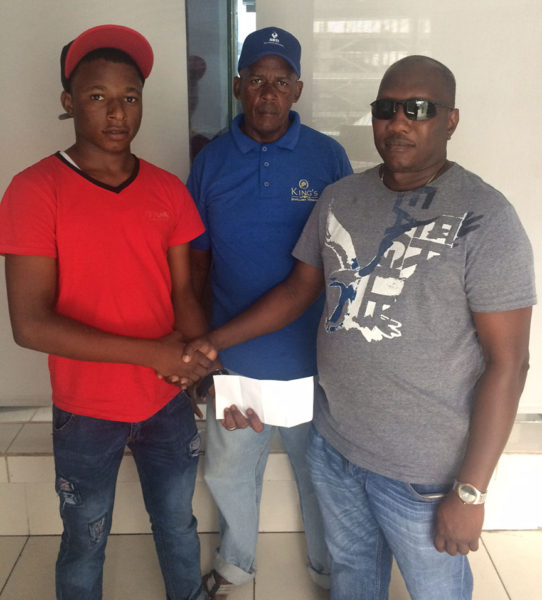 Juvenile cycle champion Zaman Khan’s (left) sojourn to the Junior Caribbean Cycling Championships was made possible by Steven Edwards (right). Coach of the team Randolph Roberts is pictured at centre. 