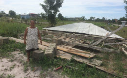 Herman Williams standing next to her sister’s half-finished house that was leveled by the storm. 