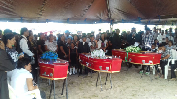 Black Bush murder victims laid to rest: Rice farmer, Pawan Chandradeo, 37; his fifteen-year-old son, Jaikarran Chandradeo, both of 163 Mibicuri North, Black Bush Polder and his brother-in-law Naresh Rooplall, 33, of Number 75 Village, Corentyne were yesterday laid to rest following an emotional funeral. They were buried at the Babu John Cemetery, Port Mourant. The trio were found dead on Friday, less than a day after they had left to go on a fishing trip in Black Bush Polder. Intense investigations are underway into the murders. Photo shows the caskets of the three victims and part of the crowd that gathered.