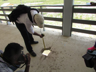 The engineer shows the dimensions of the concrete at the Kato school which he broke to measure its integrity (MPI photo) 