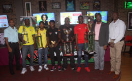 Representatives of Slingerz FC, Alpha United, Fruta Conquerors and Pele FC posing with their spoils from the Stag Beer Elite League alongside members of the GFF and ANSA McAl inclusive of Wayne Forde (2nd from right).