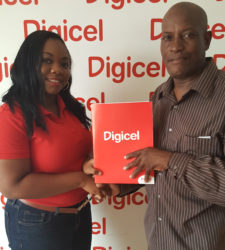 Louanna Abrams, Digicel's Sponsorship Executive, hands over the company’s sponsorship to Compton Sancho, one of the Coordinators of 10th Annual Guyana Cup. 