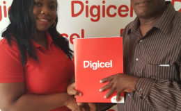 Louanna Abrams, Digicel's Sponsorship Executive, hands over the company’s sponsorship to Compton Sancho, one of the Coordinators of 10th Annual Guyana Cup.
