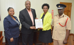 Minister of State Joseph Harmon receives the report of the Commission of Inquiry into the deaths of the victims of the Hadfield Street Drop-in Centre from Commissioner, Retired Colonel Windee Algernon (centre-right). Minister of Social Protection Volda Lawrence and acting Chief Fire Officer Winston McGregor (right), also received copies of the report. (Ministry of the Presidency photo)