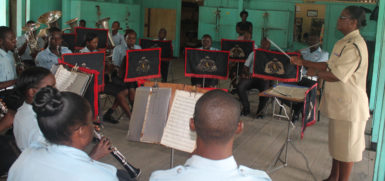 Superintendent Charmaine Stuart (standing, right) conducts the Military Band during a practice session.