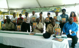 Minister of Public Security Khemraj Ramjattan (seated second, left) with members of the GNRSC and the Guyana Police Force as they display the new magazine.
