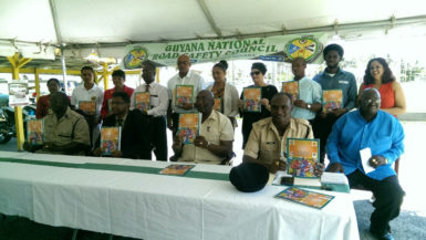 Minister of Public Security Khemraj Ramjattan (seated second, left) with members of the GNRSC and the Guyana Police Force as they display the new magazine.  