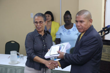 Lead Consultant Paula Trotter hands over the Assessment Reports of the five newly accredited Baby Friendly hospitals to Minister of Public Health Dr George Norton.  