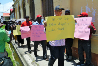 General Secretary of the PPP Clement Rohee with protesters outside the High Court yesterday 