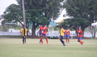 Jeremy Garrett (centre) of Fruta Conquerors in the process of receiving the ball while being pursued by Creek FC opposing player during their u17 matchup at the Camp Ayanganna ground yesterday. 