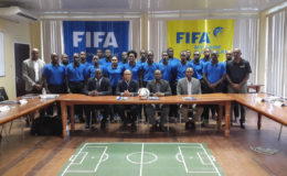 Peter Prendergast (2nd from left), FIFA Regional Development Officer/Technical Officer posing alongside GFF President Wayne Forde (2nd from right) and several of the participating referees following the conclusion of the RAP opening ceremony 