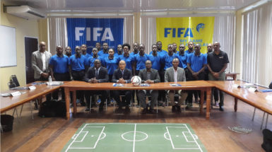 Peter Prendergast (2nd from left), FIFA Regional Development Officer/Technical Officer posing alongside GFF President Wayne Forde (2nd from right) and several of the participating referees following the conclusion of the RAP opening ceremony 