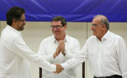 Colombia’s FARC lead negotiator Ivan Marquez (L) and Colombia’s lead government negotiator Humberto de la Calle (R) shake hands while Cuba’s Foreign Minister Bruno Rodriguez looks on, after signing a final peace deal in Havana, Cuba, August 24, 2016. REUTERS/Alexandre Meneghini
