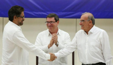 Colombia’s FARC lead negotiator Ivan Marquez (L) and Colombia’s lead government negotiator Humberto de la Calle (R) shake hands while Cuba’s Foreign Minister Bruno Rodriguez looks on, after signing a final peace deal in Havana, Cuba, August 24, 2016. REUTERS/Alexandre Meneghini  