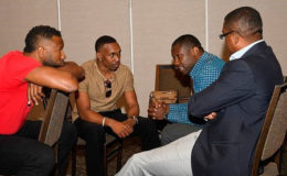 WICB president, Dave Cameron (right) chats with players Kieron Pollard (left) and Dwayne Bravo (second from left), and West Indies players union president, Wavell Hinds, during the symposiu 