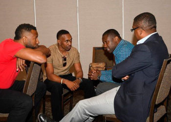 WICB president, Dave Cameron (right) chats with players Kieron Pollard (left) and Dwayne Bravo (second from left), and West Indies players union president, Wavell Hinds, during the symposiu 